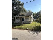 Charming bungalow featuring a cozy front porch and fenced yard at 3 Elm St, Porterdale, GA 30014