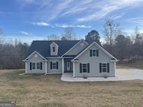 Charming single-story home with gray siding, black shutters, and a well-maintained front yard at 1029 Hines Rd, Moreland, GA 30259