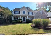 Charming two-story home featuring a manicured front yard, covered porch, and classic curb appeal at 976 Buckhorn Bnd, Locust Grove, GA 30248