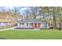 Charming single-story home boasts a well-manicured lawn and a vibrant red front door at 791 Gertrude Nw Pl, Atlanta, GA 30318