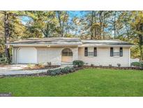 Charming brick home with a well-manicured lawn and beautiful landscaping at 2205 Chestnut Hill Cir, Decatur, GA 30032