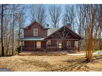 Charming log cabin home featuring a covered front porch and well-maintained landscaping at 1225 Pitts Chapel E, Newborn, GA 30056