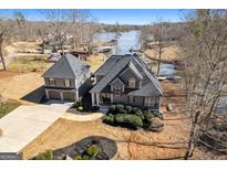A beautiful lake house with lush landscaping and a detached two-car garage and water access to the lake at 50 Birch Rd, Covington, GA 30014
