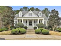 Charming home featuring a symmetrical facade, manicured landscaping, and a welcoming front porch at 605 St. Charles Pl, Fayetteville, GA 30215