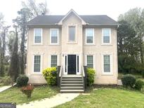 Two-story home showcasing a black front door, and a well-manicured lawn and shrubbery at 3497 Thornewoode Pointe, Decatur, GA 30034