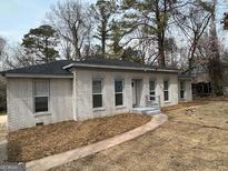 Charming brick home with a well-maintained front yard featuring freshly laid mulch and an inviting walkway at 5205 Kings Hwy, Douglasville, GA 30135