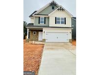 Two-story home featuring a two-car garage, stone accents, and a mix of siding and shake exterior finishes at 11192 Cornerstone Way, Hampton, GA 30228