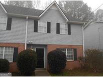Charming two-story townhome featuring gray siding, brick accents, and well-maintained front shrubs at 4341 Logan Way, Acworth, GA 30101