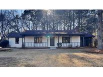 Charming single-story home featuring a cozy front porch and a well-maintained front yard at 30 Fairfield Dr, Ellenwood, GA 30294