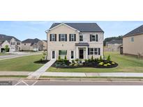 Charming two-story home with a combination of brick and stone exterior and manicured landscaping at 615 Edgar St # 13, Hampton, GA 30228