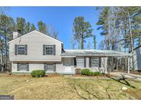 Charming home featuring a front yard with mature trees and an attached carport for convenient parking at 599 Raintree Dr, Jonesboro, GA 30238