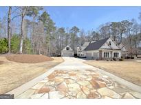 Beautiful home exterior showcasing a stone driveway and three-car garage at 209 Wynnward Way, Sharpsburg, GA 30277