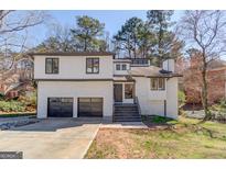 Charming home with a two-car garage, stone facade, and inviting entrance steps at 5284 Silver Creek Sw Dr, Lilburn, GA 30047