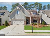 Charming single-Gathering home featuring a blend of brick and siding, a well-manicured lawn and a two-car garage at 3390 Steinbeck St, Cumming, GA 30041