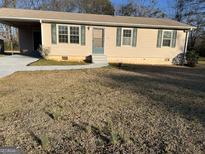 Charming single-story home with tan siding, green shutters, and a covered carport at 30 Lemon Pl, Mcdonough, GA 30253