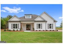 Charming white farmhouse with symmetrical design, dark shutters, covered entry, and a well-manicured lawn at 140 Paislee Park (Lot #5 Paislee Park) Dr, Fayetteville, GA 30215