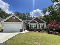 Charming single-Gathering home featuring a manicured front lawn and a two-car garage at 9178 Lakeview Pkwy, Villa Rica, GA 30180