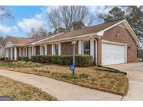 Charming brick home featuring a two-car garage, manicured bushes, and a well-kept lawn at 210 Heritage Cir, Mcdonough, GA 30253