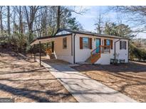 Charming white brick home with a cozy carport and a bright blue front door at 3650 Adkins Nw Rd, Atlanta, GA 30331
