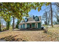 Charming two-story home with a covered front porch and dormer windows nestled under mature trees at 1444 Norman Berry Dr, East Point, GA 30344