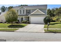 Charming two-story home with a well-manicured lawn and a two-car garage at 80 Rosemoore Dr, Covington, GA 30014
