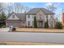 Charming two-story home boasts a stone facade, well-manicured lawn, and an attached two-car garage at 809 Byrnwyck Ne Rd, Brookhaven, GA 30319