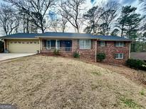 Charming brick home with a cozy front porch and a well-manicured lawn at 365 Jordan Dr, Tucker, GA 30084