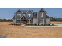 Charming two-story home features vertical siding, an inviting entryway, and a well-manicured lawn at 180 Paislee Park (Lot #9 Paislee Park) Dr, Fayetteville, GA 30215