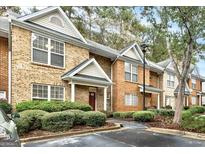 Brick townhome exterior showcasing manicured landscaping and assigned parking at 3802 Austin Park Ln, Decatur, GA 30032