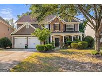 Two-story home boasts stone and siding, a two-car garage, and manicured landscaping at 4770 Shiloh Springs Rd, Cumming, GA 30040