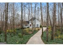 Charming two-story home with a gray facade, surrounded by mature trees and lush greenery at 40 Woodbrook Ct, Mcdonough, GA 30252