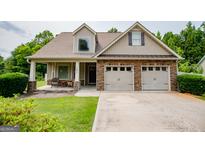 Charming home featuring a stone and vinyl exterior, two-car garage, and covered front porch at 101 Deer Park Dr, Carrollton, GA 30116