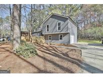 Attractive two-story home with gray siding, wooden deck, and lush landscaping at 1967 Levgard Ln, Riverdale, GA 30296