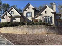 Stately brick home featuring multi-level roof lines and manicured landscaping at 852 Oakton Pond Nw Ct, Marietta, GA 30064