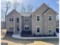 Two-story brick home featuring a manicured lawn, and complemented by detailed window framing and an arched entry at 5905 Langdale Chase # 17, Douglasville, GA 30135