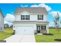 New construction home featuring white siding, a two-car garage, and a well-manicured lawn at 291 Limestone Circle, Conyers, GA 30013