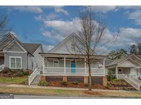 Charming two-story home featuring a spacious front porch with blue door and well-maintained landscaping at 5118 N Pratt St, Covington, GA 30014