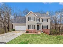 Charming two-story home featuring a manicured lawn, two-car garage, and classic brick accents at 1320 Kay Se Ter, Conyers, GA 30013