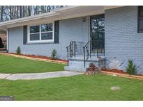 Charming single-story home with a brick facade, updated window, and manicured lawn at 3983 E Hilda Cir, Decatur, GA 30035