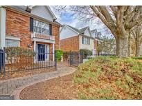 Charming brick townhome featuring a manicured front yard and walkway, inviting curb appeal at 498 N Jeff Davis Dr, Fayetteville, GA 30214