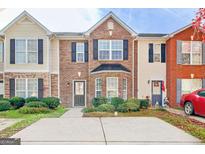 Charming brick townhouse with black shutters and neatly landscaped front yard at 1915 Grove Way, Hampton, GA 30228