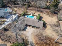 Stunning aerial view of a property featuring a sparkling pool, fire pit, and beautiful landscaping at 311 Pinemount Dr, Peachtree City, GA 30269