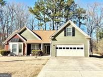 Charming one-story home features an attached two-car garage, manicured lawn, and welcoming facade at 222 Sandstone Dr, Hampton, GA 30228