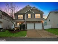 Charming two-story home featuring a two-car garage, stone accents, and well-manicured lawn at 70 High Point Way, Hiram, GA 30141