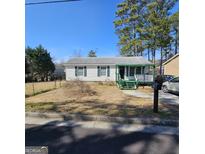 Charming single-story home featuring a cozy front porch and a well-maintained yard at 4748 Ash St, Doraville, GA 30340