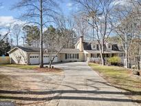 Charming home with a long driveway and a spacious three-car garage surrounded by mature trees at 444 Pineview Dr, Canton, GA 30114