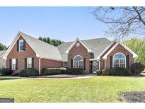 Beautiful brick home with a well-manicured lawn and mature landscaping at 1000 Maria Dr, Mcdonough, GA 30253
