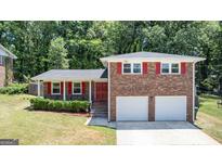 Charming brick home with vibrant red shutters, a welcoming front door, and a well-manicured lawn at 3216 Pheasant Dr, Decatur, GA 30034