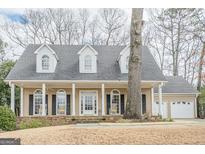 Charming home featuring a welcoming front porch with a stone base and a beautiful facade at 6360 Brookline Ct, Cumming, GA 30040