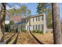 Traditional two-story home featuring a symmetrical facade, shutters, and landscaped front yard at 557 Spring Creek Ne Way, Marietta, GA 30068